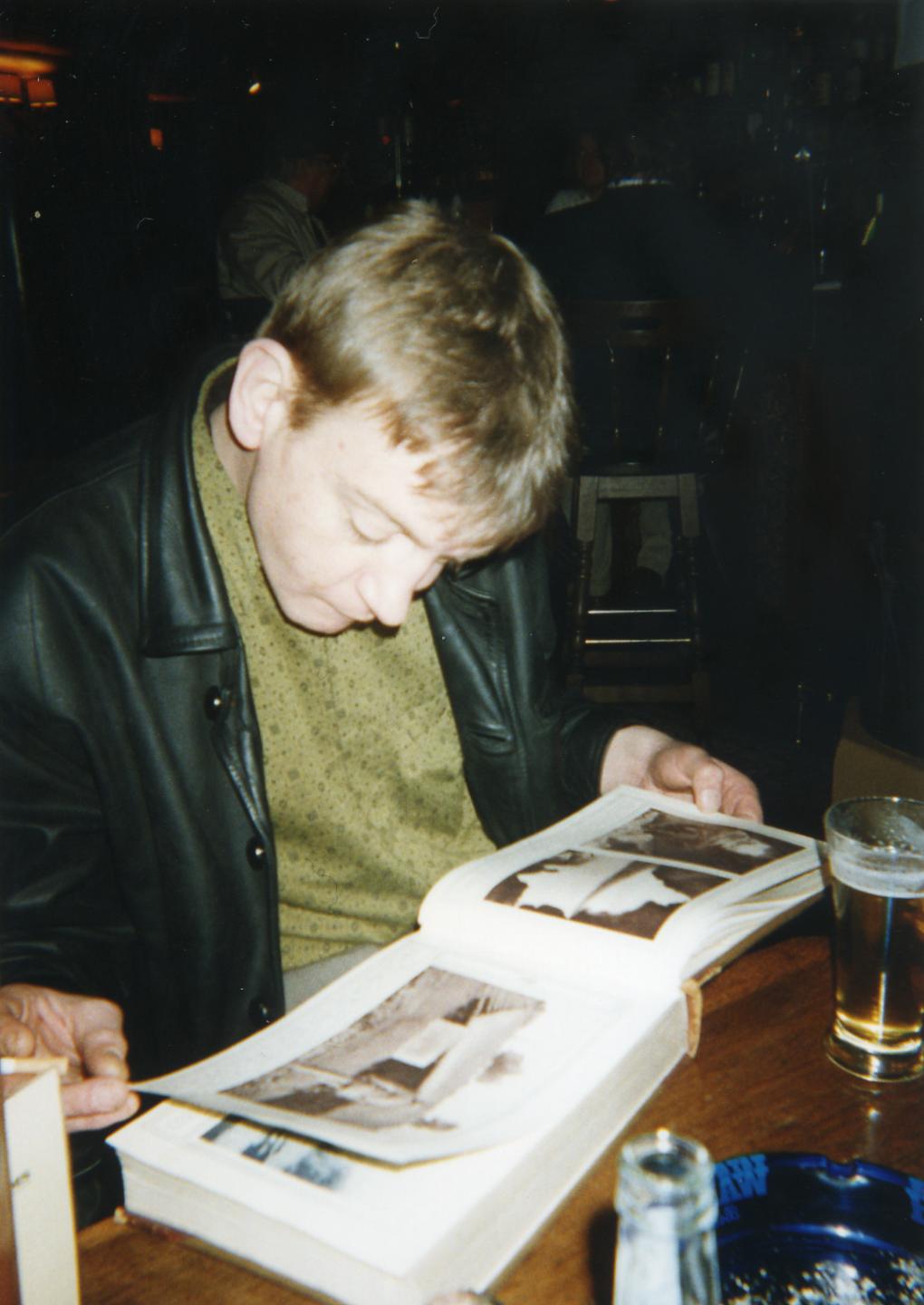Mark E Smith reading during tour transit